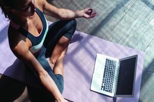 Woman in Yoga Pose in Front of Her Laptop