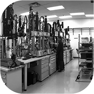 Black-and-White Photo of a Line of Universal Testing Machines Used for Tensile and Fatigue Testing