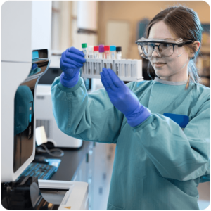 Scientist in Lab Coat Reviewing Liquid Samples